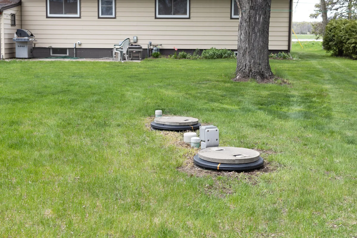 A residential septic system with tank access lids installed in a backyard lawn - illustrative stock photo, not an actual Pahrump job site